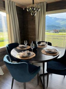 a dining room table with plates and wine glasses at Karnes Lodge in Oksevik