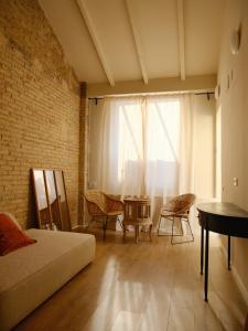 a living room with a couch and a table and a window at Casa Reina Cabanyal in Valencia