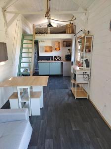 a living room with a table and a kitchen at La tiny house in Bissières