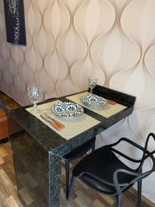 a black table with two plates and glasses on it at Residencial Beatriz centro in Formosa