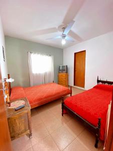a bedroom with two beds and a television in it at Shekináh in Villa Cura Brochero