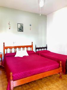 a bedroom with two beds with red sheets at Shekináh in Villa Cura Brochero +44 photos