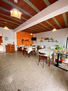 a dining room with tables and chairs and a tv at Shekináh in Villa Cura Brochero