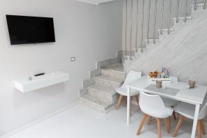 a white dining room with a white table and chairs at A casa dello scalpellino in Contursi