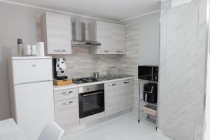 a white kitchen with a stove and a refrigerator at A casa dello scalpellino in Contursi