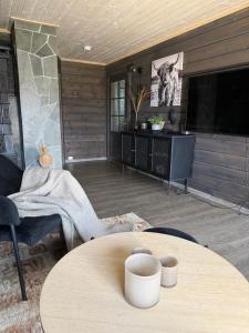 a living room with a table and a tv at Karnes Lodge in Oksevik