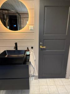 a bathroom with a sink and a mirror at Karnes Lodge in Oksevik +33 photos