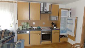 a kitchen with wooden cabinets and a sink and a refrigerator at Landidyll in Ummanz