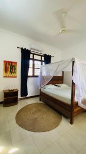 a bedroom with a bed with a canopy at Fish House in Nungwi