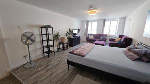 a bedroom with a large bed and a living room at Studio- Gemütlich, Charmant, Zentral in Landsberg am Lech