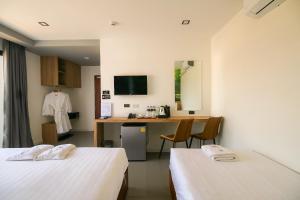a hotel room with two beds and a desk at M&M Hotel in Vang Vieng +22 photos