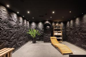 a room with a stone wall with a wooden bench at ODAYA Social Hotel Bansko in Bansko +227 photos
