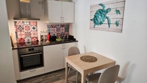 a kitchen with a small table and a kitchen with a stove at Studio- Gemütlich, Charmant, Zentral in Landsberg am Lech