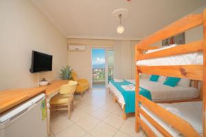 a room with two bunk beds and a desk with a computer at Kampüs Garden in Fethiye