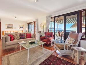 a living room with a couch and a table at Eindelik in Simonʼs Town