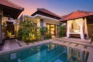 a villa with a swimming pool and a house at Lapiz Lazuli in Seminyak