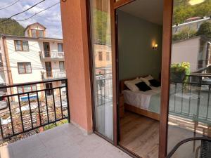 a room with a balcony with a bed on a balcony at Memory- borjomi in Borjomi
