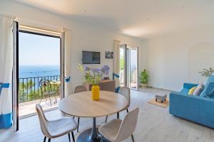 a living room with a table and a blue couch at Santa Rosa Relais in Conca dei Marini