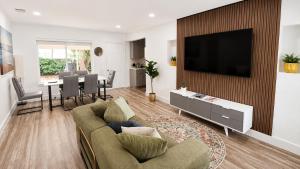 a living room with a couch and a television on a wall at Cozy Private Triple Room in Design District Miami in Miami +3 photos
