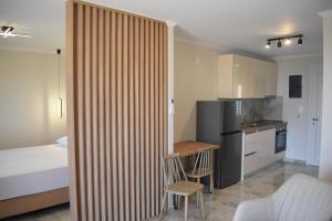 a room with a bed and a kitchen with a table and chairs at Sun Studios Pieria in Paralía Skotínis
