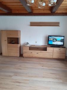 a living room with a flat screen tv on a wooden cabinet at Haus-Johanna in Riedlhütte