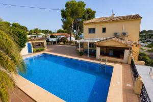 a swimming pool in front of a house at Villa Paula in Benissa