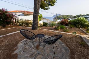 two chairs sitting next to a tree in a yard at Villa Paula in Benissa