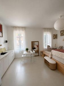 a white room with a bed and a table at Studios Riviera in Bandol