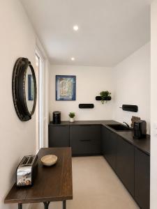 a kitchen with black cabinets and a table and a sink at Studios Riviera in Bandol