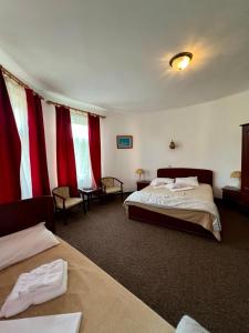 a hotel room with two beds and red curtains at Vila Randunica in Eforie Sud
