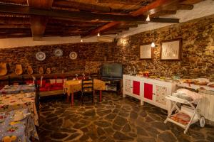 a living room with a television and a table and chairs at Monte Pedras Negras in São Luis