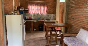 a kitchen with a table and a refrigerator in a room at Villa Virgen De La Gracia in Tobatí