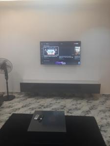 a room with a tv on a white wall at Jasper luxury homes in Abuja