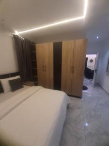 a bedroom with a large bed and wooden cabinets at Jasper luxury homes in Abuja