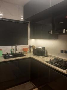 a kitchen with black cabinets and a sink at Jasper luxury homes in Abuja