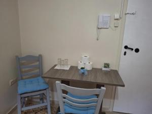 a wooden table and two chairs in a room at Salamina Sea View in Kakí Vígla
