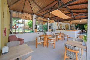 a restaurant with tables and chairs and a bar at Kampüs Garden in Fethiye