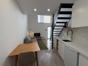 a kitchen and a living room with a staircase at AlvaLoft Barreiro in Barreiro