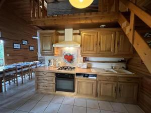 a kitchen with wooden cabinets and a stove top oven at Chalet des dunes in Biscarrosse +16 photos