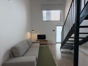 a living room with a couch and a television at AlvaLoft Barreiro in Barreiro