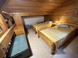 a room with two beds in a log cabin at Chalet des dunes in Biscarrosse