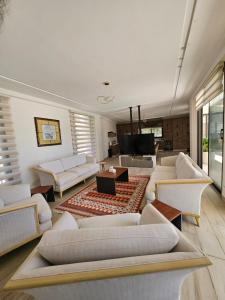 a living room with white couches and a television at Sun farm souf in Jerash