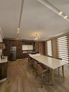 a kitchen with a large white table and chairs at Sun farm souf in Jerash