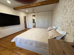 a bedroom with a large bed and a flat screen tv at Дом с бассейном и мангальной зоной in Ustʼ-Kamenogorsk +10 photos