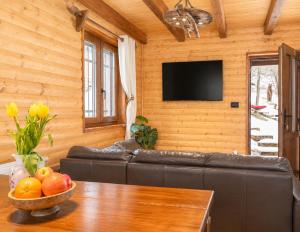 a living room with a couch and a bowl of fruit on a table at Kuća za odmor Cozy Bear Cabin in Brestova Draga