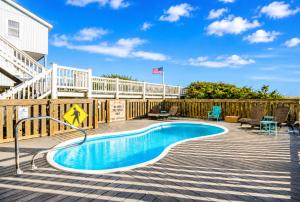 a swimming pool on a deck next to a house at Oceanfront luxury, private pool & beach access! in Holden Beach