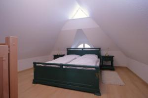 a bedroom with a green bed in a attic at Haus Koppelweg FW-Fisch in Ahrenshoop