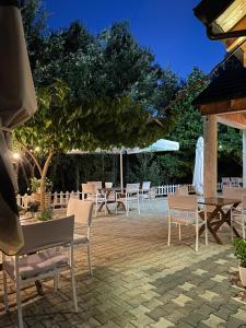 a patio with tables and chairs at night at Shija e Natyres in Reç