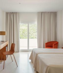 a bedroom with a bed and two chairs and a window at Hotel Santamarta in Cullera +35 photos