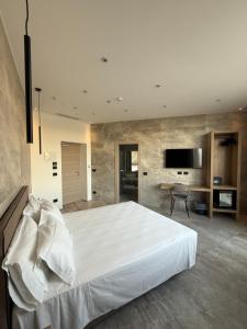 a bedroom with a large white bed and a television at Hotel Corona in Termoli